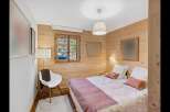 Experience rustic charm in this cozy bedroom featuring warm wood paneling throughout.