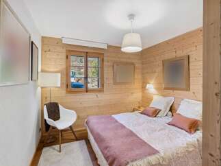 Experience rustic charm in this cozy bedroom featuring warm wood paneling throughout.