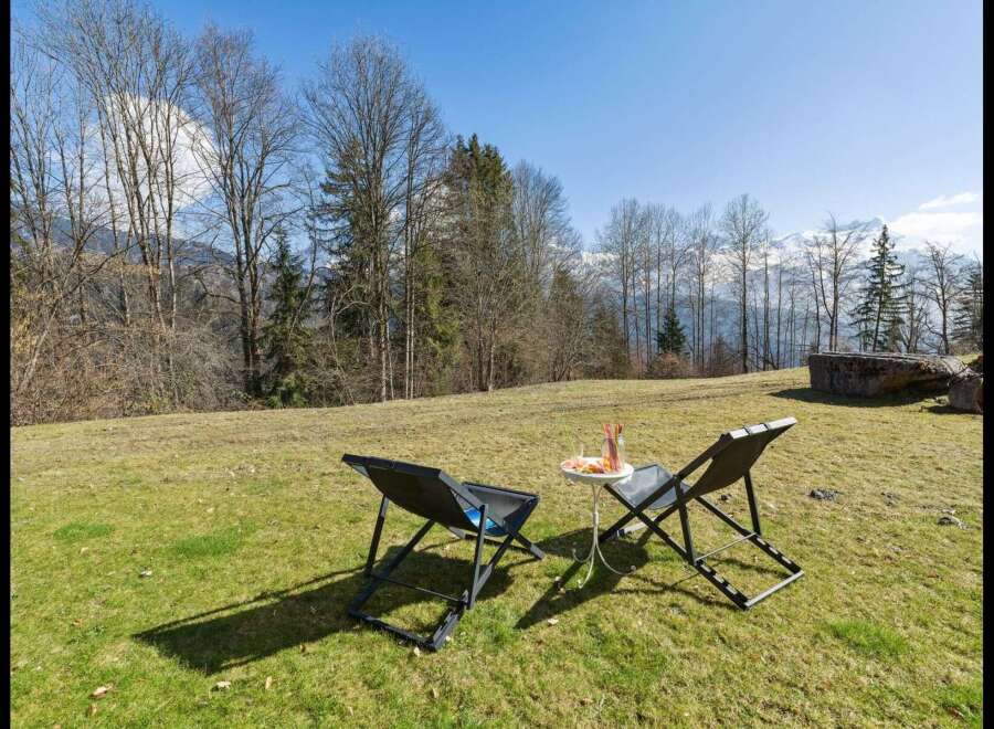 Enjoy breathtaking mountain views from this serene outdoor seating area, perfect for relaxing with a refreshing drink.