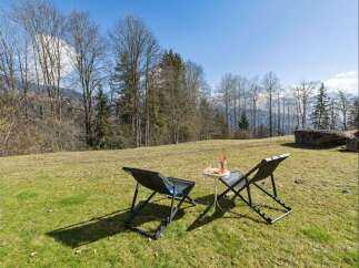 Enjoy breathtaking mountain views from this serene outdoor seating area, perfect for relaxing with a refreshing drink.