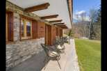 Experience alpine charm with this property featuring a rustic stone facade and traditional wooden shutters.