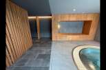 Experience tranquility in this modern spa oasis, featuring a soothing pool and elegant wooden accents.