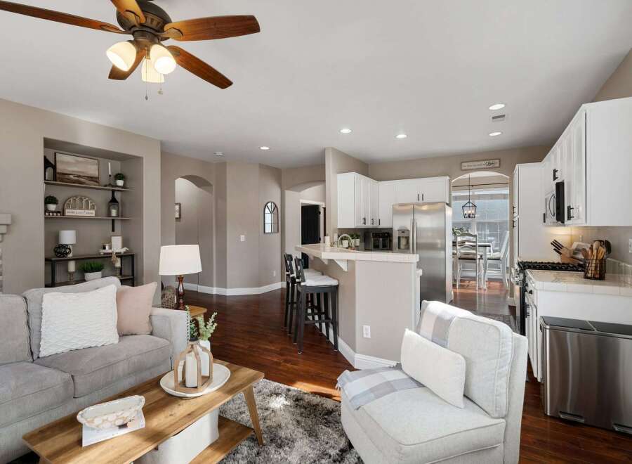 Experience open-concept living in this beautifully appointed home, featuring a spacious living area flowing seamlessly into a modern kitchen with ample cabinet space and a convenient breakfast bar.