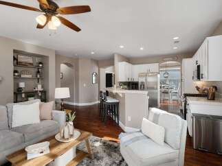 Experience open-concept living in this beautifully appointed home, featuring a spacious living area flowing seamlessly into a modern kitchen with ample cabinet space and a convenient breakfast bar.