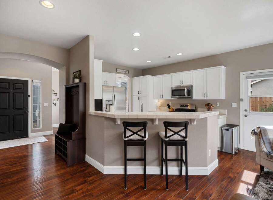 Step into this inviting kitchen featuring crisp white cabinetry and a convenient breakfast bar, perfect for casual dining.