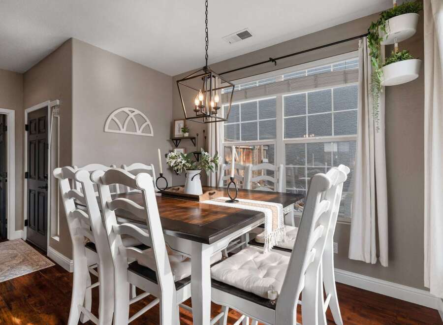 This charming dining room features a beautiful dark wood table with white chairs, perfect for family gatherings.