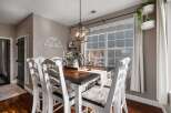 This charming dining room features a beautiful dark wood table with white chairs, perfect for family gatherings.