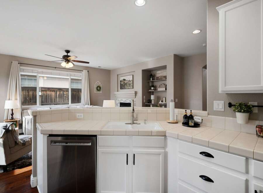 This kitchen features a spacious white sink and ample counter space, perfect for meal preparation.
