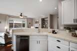 This kitchen features a spacious white sink and ample counter space, perfect for meal preparation.