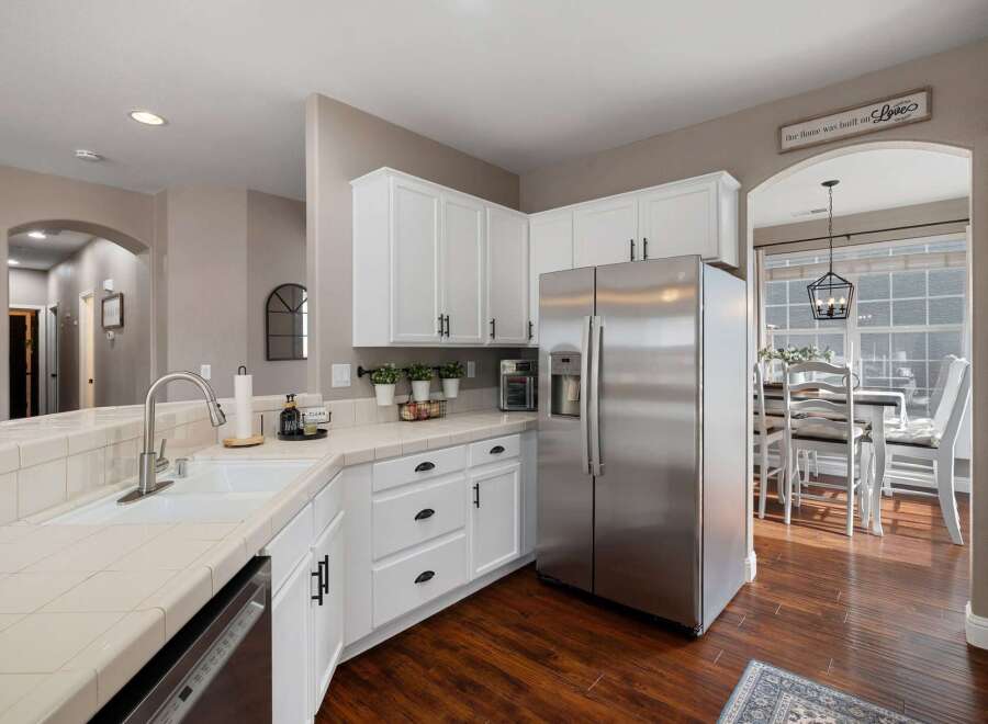 Discover this beautifully updated kitchen featuring sleek stainless steel appliances, including a French door refrigerator and a built-in microwave.