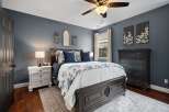 Discover this inviting bedroom featuring a dark wood bed frame with ample storage, complemented by a blue and white floral comforter.