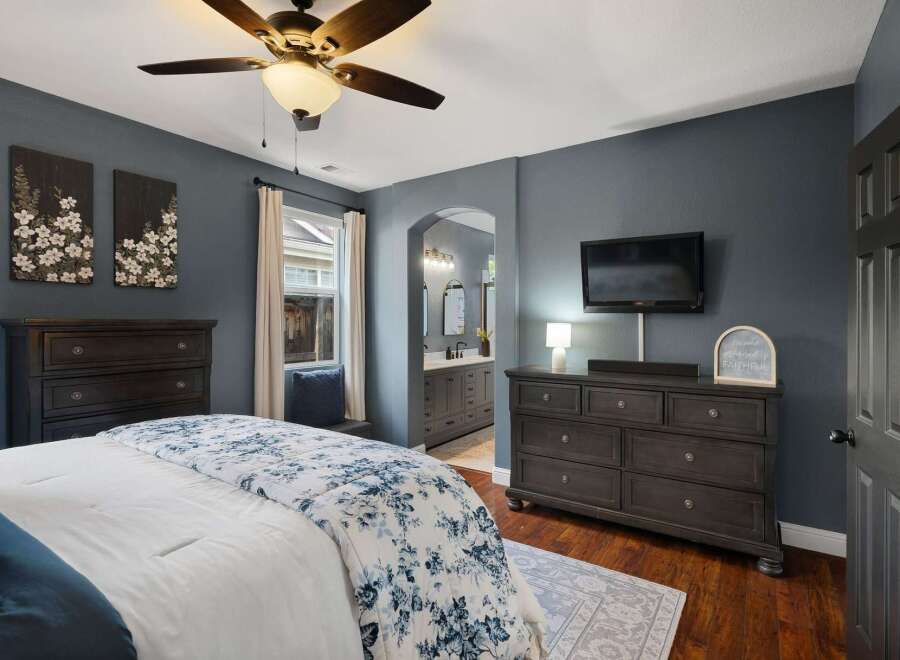 Experience ultimate comfort in this master bedroom, featuring a luxurious king-size bed adorned with a beautiful floral comforter.