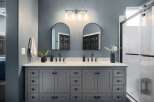 Experience luxury in this modern bathroom featuring a spacious double vanity with sleek black fixtures and ample storage.