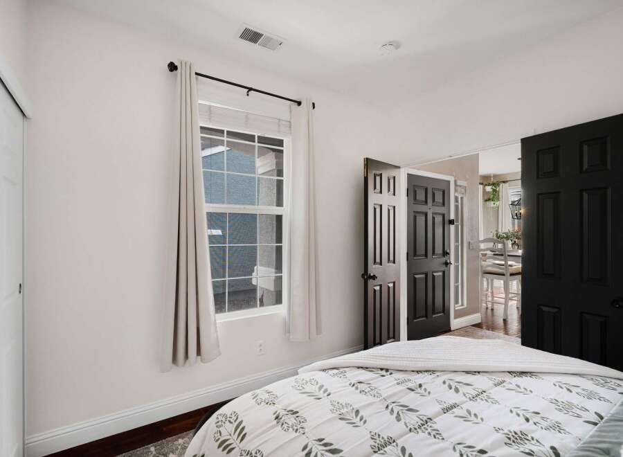 Step into this inviting bedroom featuring a comfortable bed with a botanical-print comforter, perfect for restful nights.