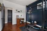 This versatile room offers a dedicated workspace with a charming wooden desk and lamp, perfect for productivity.