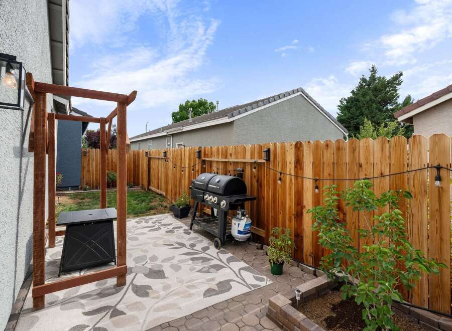 Enjoy outdoor living in this charming backyard featuring a spacious patio area perfect for entertaining.
