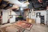 This spacious garage offers abundant storage solutions, including overhead bins and wall-mounted shelving, perfect for organizing tools and equipment.