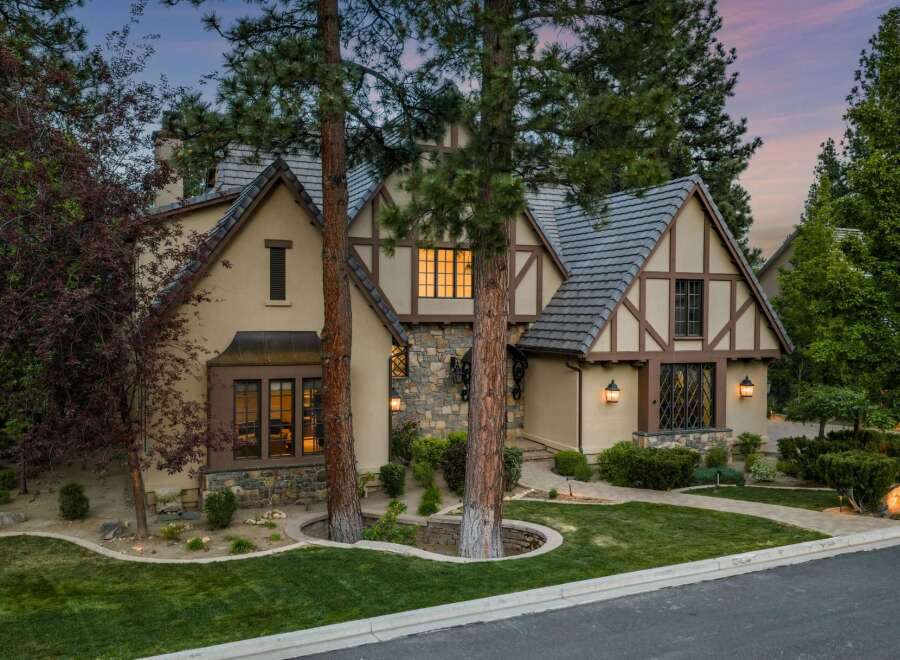 Experience timeless elegance in this stunning Tudor-style home, featuring charming half-timbered accents and a stone facade.