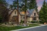 Experience timeless elegance in this stunning Tudor-style home, featuring charming half-timbered accents and a stone facade.