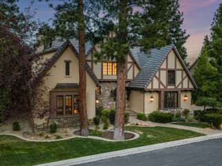 Experience timeless elegance in this stunning Tudor-style home, featuring charming half-timbered accents and a stone facade.