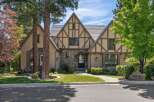 This stunning Tudor-style home boasts charming half-timbered accents and a stone-clad facade, creating a picturesque curb appeal.