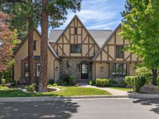 This stunning Tudor-style home boasts charming half-timbered accents and a stone-clad facade, creating a picturesque curb appeal.