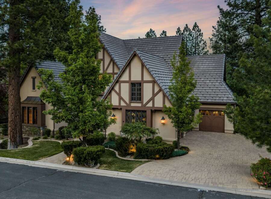 Discover this stunning Tudor-style home nestled amongst mature trees, offering a picturesque setting.