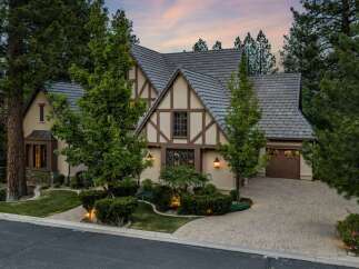 Discover this stunning Tudor-style home nestled amongst mature trees, offering a picturesque setting.
