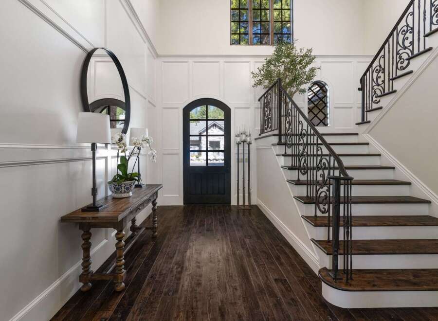 Step into a grand foyer featuring elegant wainscoting and a striking arched doorway.