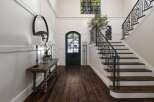 Step into a grand foyer featuring elegant wainscoting and a striking arched doorway.
