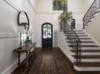 Step into a grand foyer featuring elegant wainscoting and a striking arched doorway.
