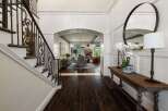 Step into a grand foyer featuring a stunning wrought iron staircase and elegant wainscoting.
