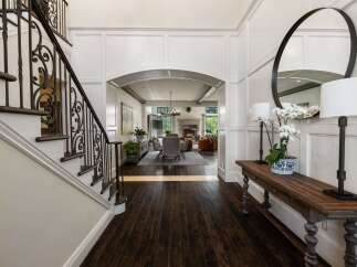 Step into a grand foyer featuring a stunning wrought iron staircase and elegant wainscoting.