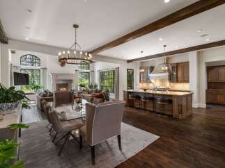 Experience luxurious open-concept living in this stunning home, featuring a grand fireplace and a spacious dining area perfect for entertaining.