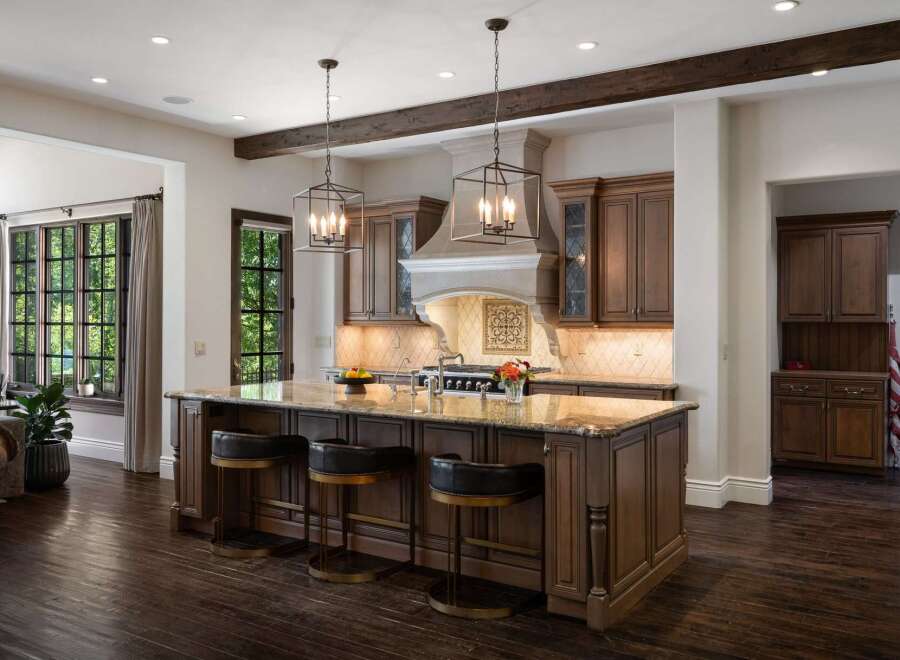 Experience luxury in this stunning kitchen featuring a large granite island with comfortable bar seating, perfect for entertaining.