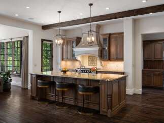 Experience luxury in this stunning kitchen featuring a large granite island with comfortable bar seating, perfect for entertaining.