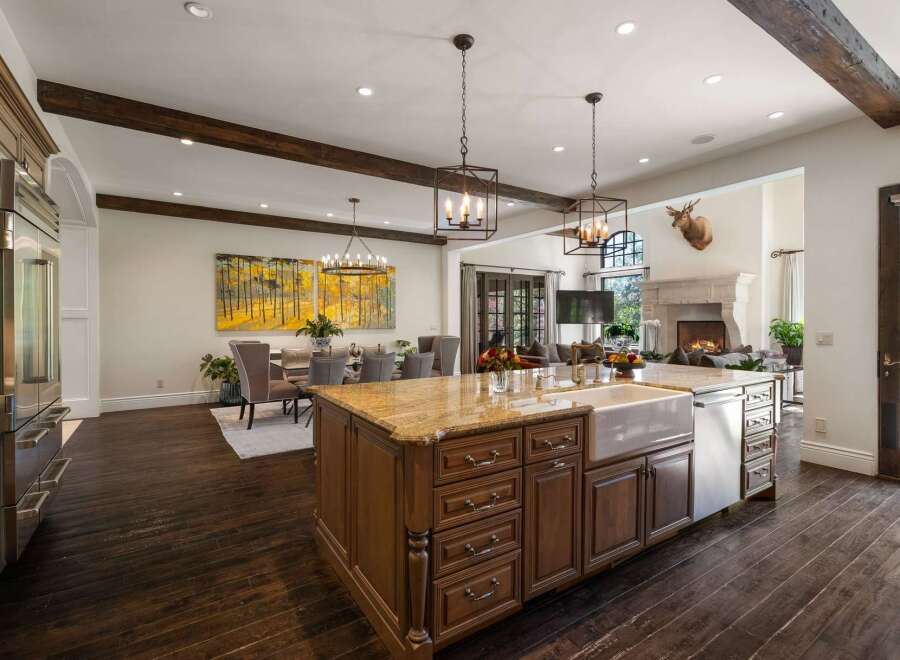 Experience luxury living in this expansive open-concept home, featuring a gourmet kitchen with a large island and farmhouse sink, perfect for entertaining.