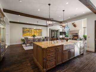 Experience luxury living in this expansive open-concept home, featuring a gourmet kitchen with a large island and farmhouse sink, perfect for entertaining.