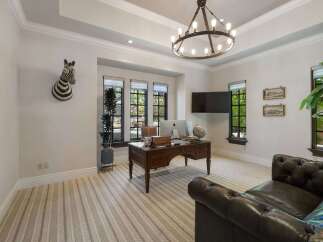 This executive office features a large wooden desk with a computer and globe, perfect for productivity.