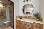 This beautifully appointed bathroom features a spacious vanity with ample storage and a decorative tile backsplash.