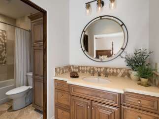 This beautifully appointed bathroom features a spacious vanity with ample storage and a decorative tile backsplash.
