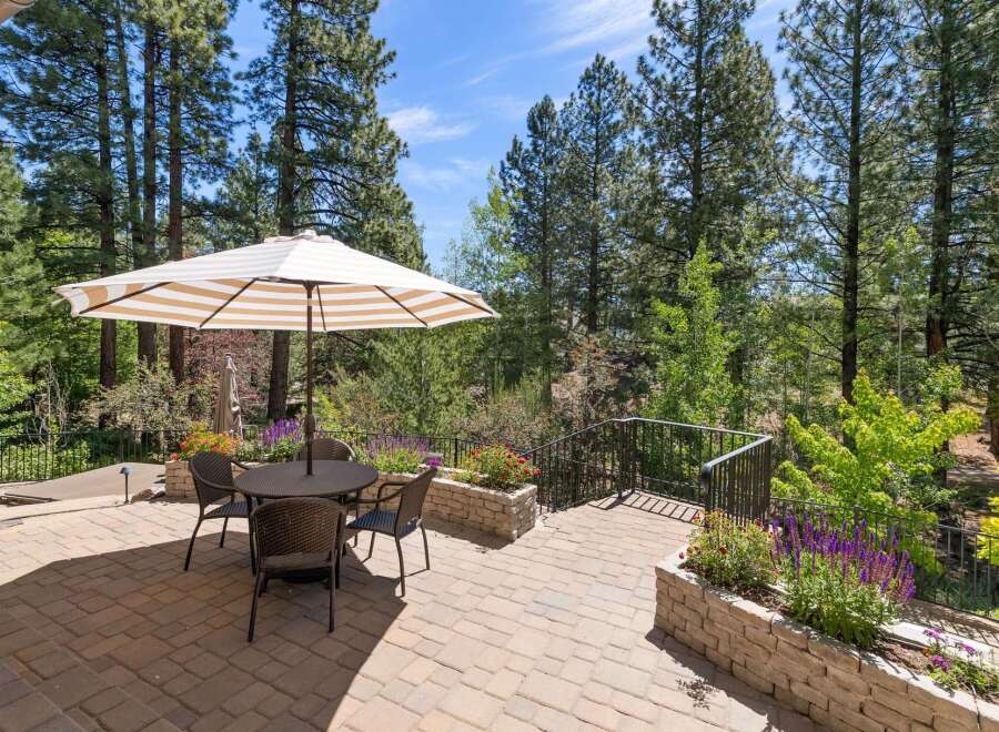 Enjoy outdoor living on this beautiful paved patio, complete with a dining set and umbrella, perfect for al fresco meals.