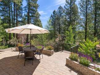 Enjoy outdoor living on this beautiful paved patio, complete with a dining set and umbrella, perfect for al fresco meals.