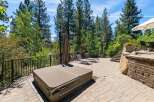 Enjoy outdoor living at its finest with this spacious patio featuring a covered hot tub and two comfortable lounge chairs, perfect for relaxation.