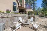 Enjoy outdoor living at its finest with this beautifully designed patio featuring a stone fire pit and comfortable Adirondack chairs, perfect for gathering with friends and family.