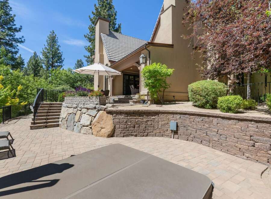 Enjoy outdoor living at its finest with this expansive patio featuring a luxurious hot tub and comfortable lounge chairs.