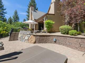 Enjoy outdoor living at its finest with this expansive patio featuring a luxurious hot tub and comfortable lounge chairs.