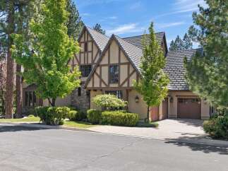Discover this stunning Tudor-style home featuring a charming facade with decorative half-timbering and a stone accent wall.