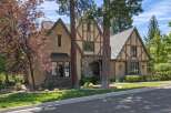 Discover this charming Tudor-style home featuring a striking stone entryway and intricate half-timbered accents.