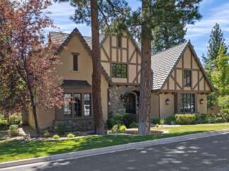 Discover this charming Tudor-style home featuring a striking stone entryway and intricate half-timbered accents.